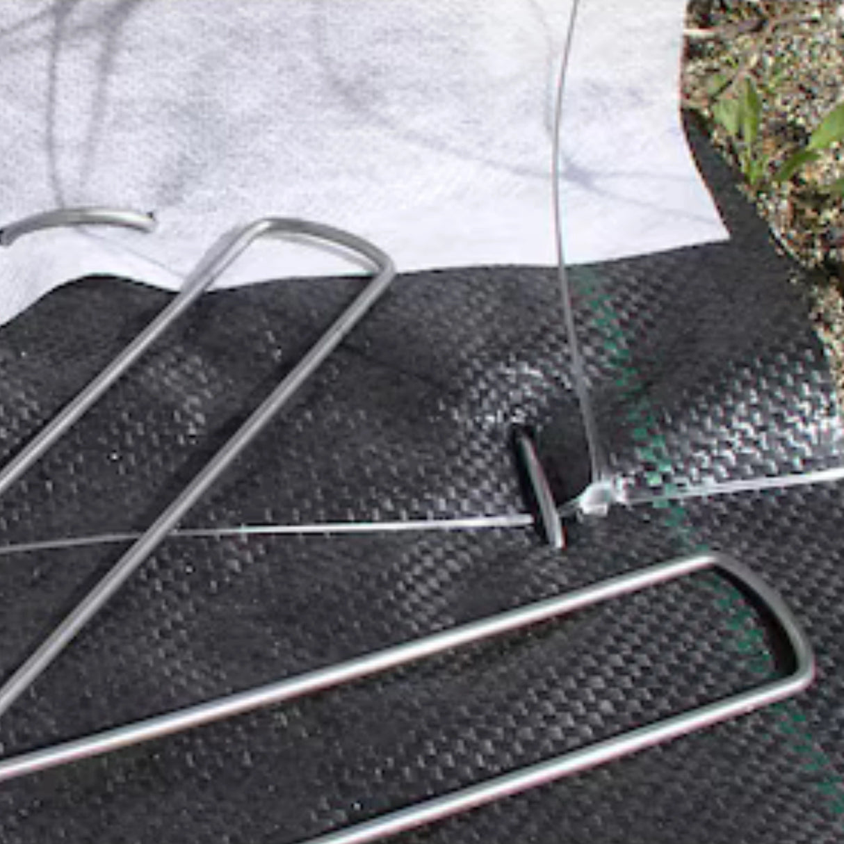 American Netting Metal Fabric Staples in use on landscape fabric outdoors in Kamloops, British Columbia