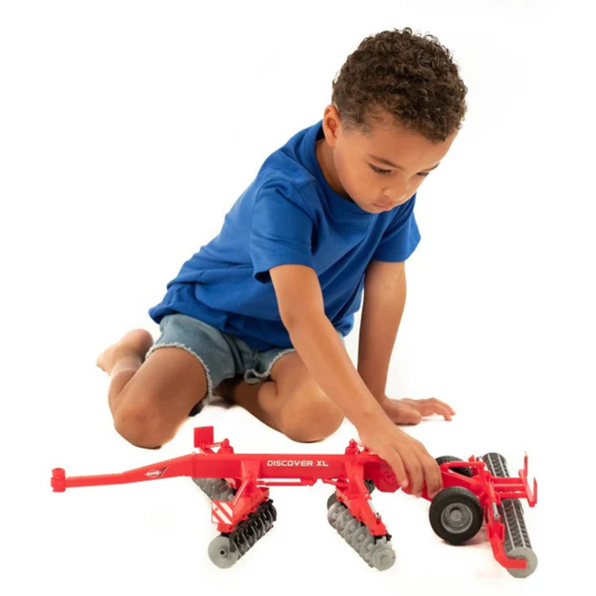 A Bruder Kuhn Discover XL Disc Harrow Bruder toy being played by a kid indoors