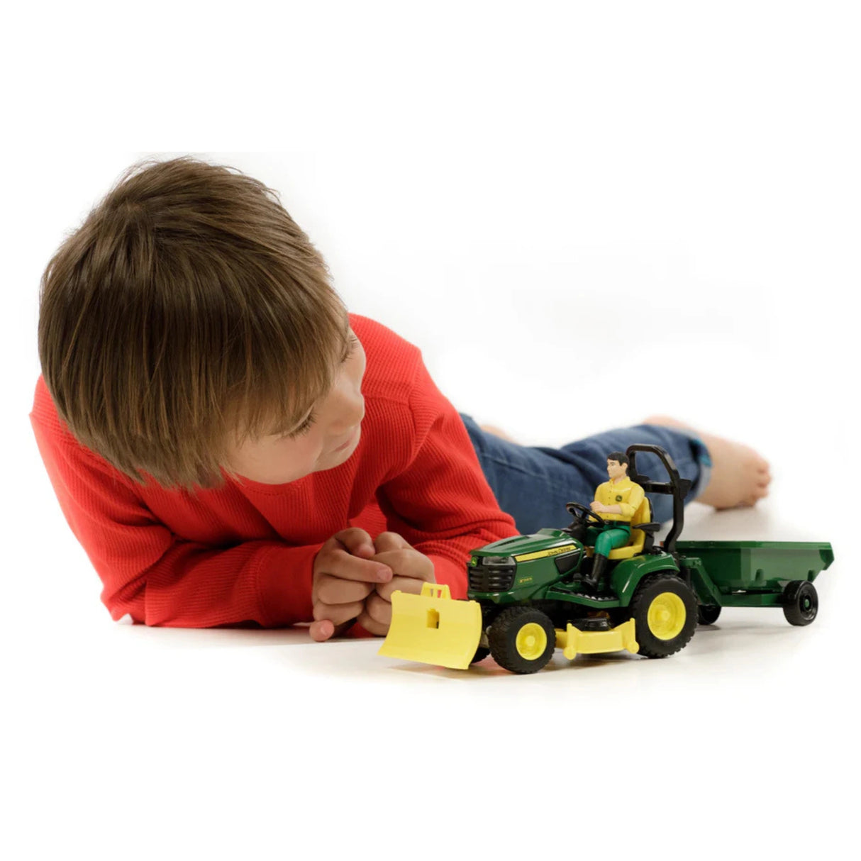 Bruder John Deere Toy Lawn Tractor and Trailer Set being played by a child indoors