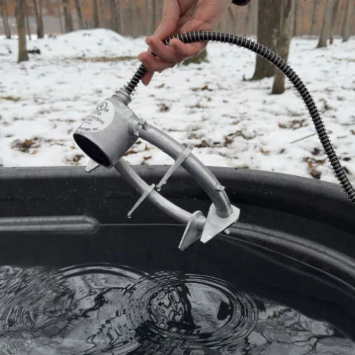 A person using the Farm Innovators 1000W Aluminum Submergible De-Icer outdoors in Kamloops, British Columbia