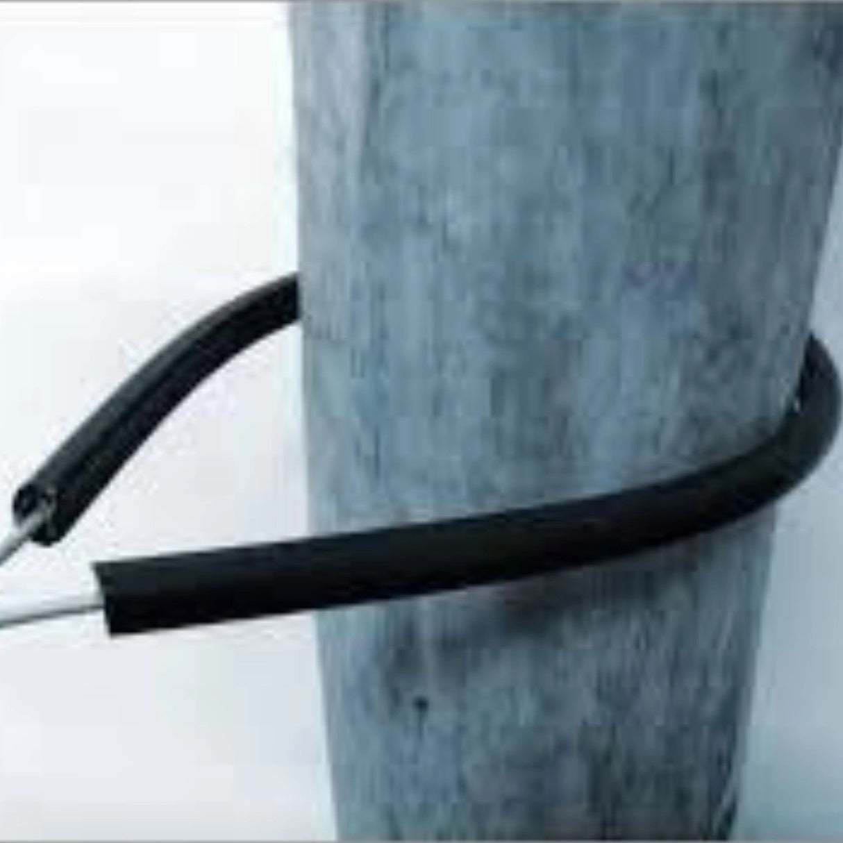 Tru-Test Electric Fence Insulators 24 inch Wrap Around 10S in use on a wooden fence post