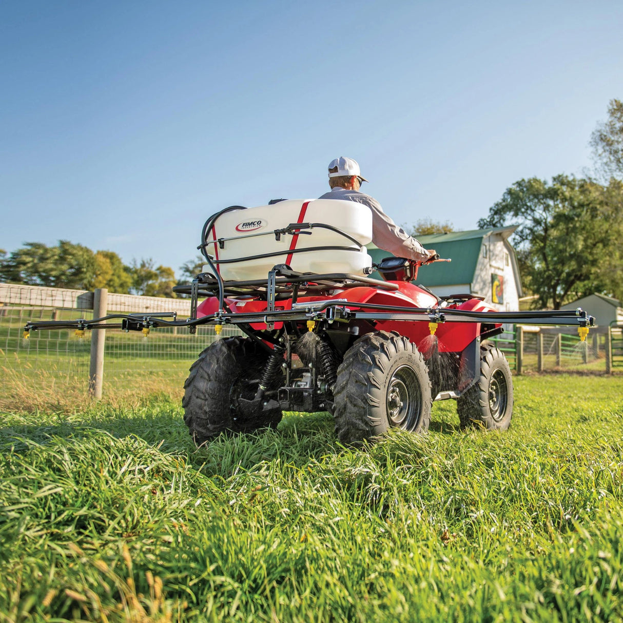 A man using Fimco ATV Sprayer 25 Gallon 7 Nozzle Broadcast Boom 2320 in the outdoors, Kamloops, British Columbia