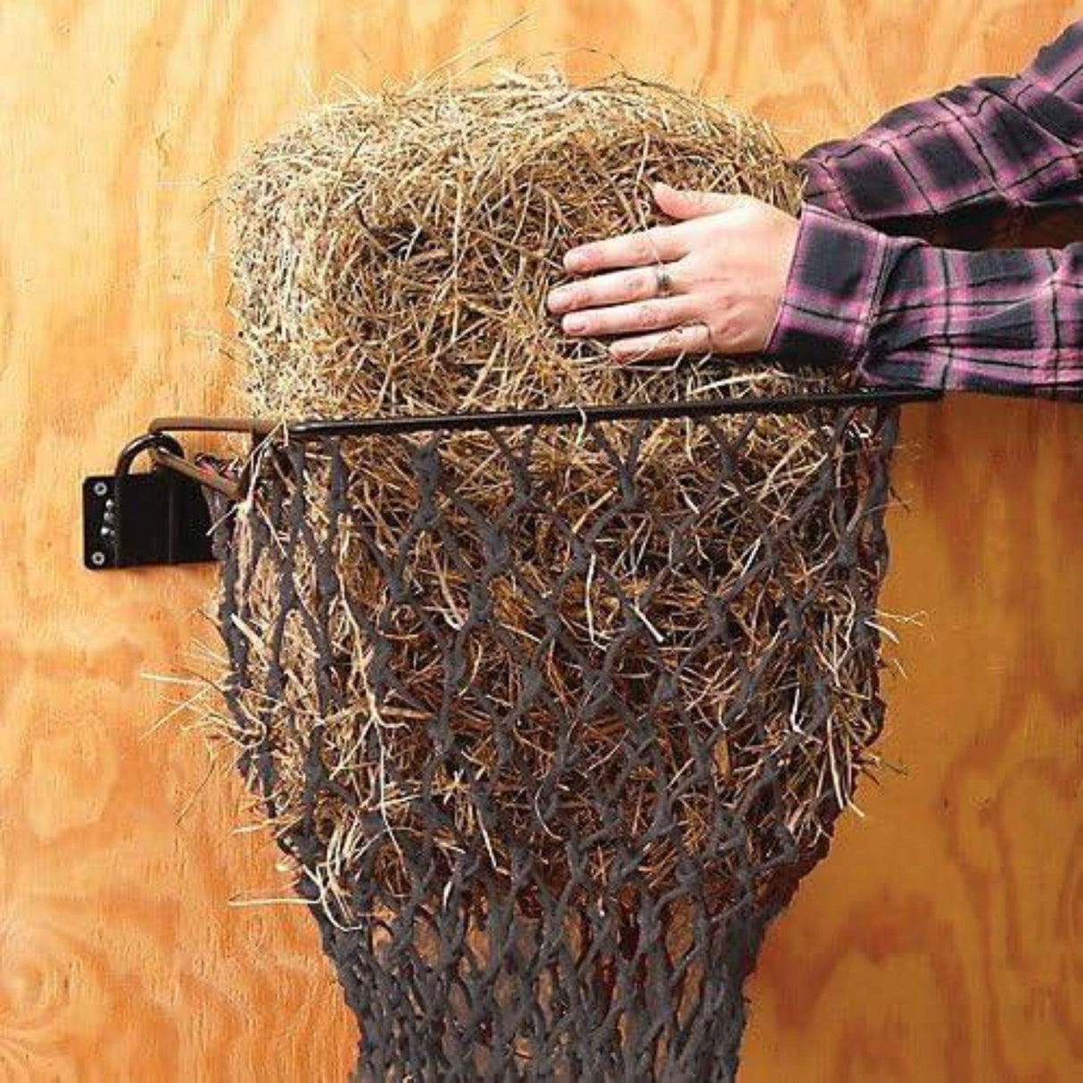 ATough-1 Hay Net Quick Assemble Hay Feeder with Net on a white background installed on a wall, filled with hay