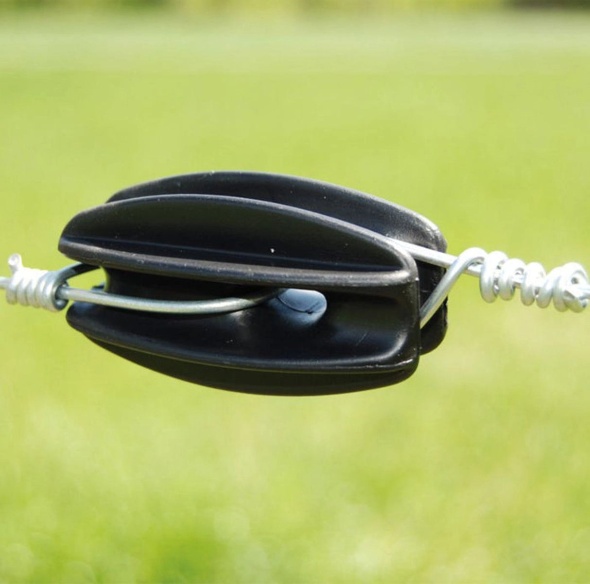 In-use view of Patriot Electric Fence Insulators installed on a fence post outdoors in the outdoors of Kamloops, British Columbia
