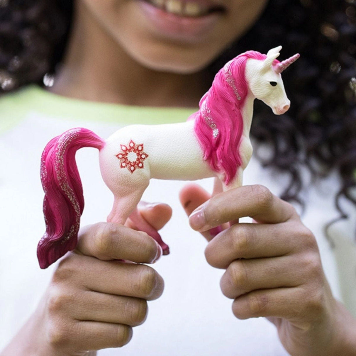 A young girl engaging with the Schleich unicorn toy inside a playroom filled with fantasy toys