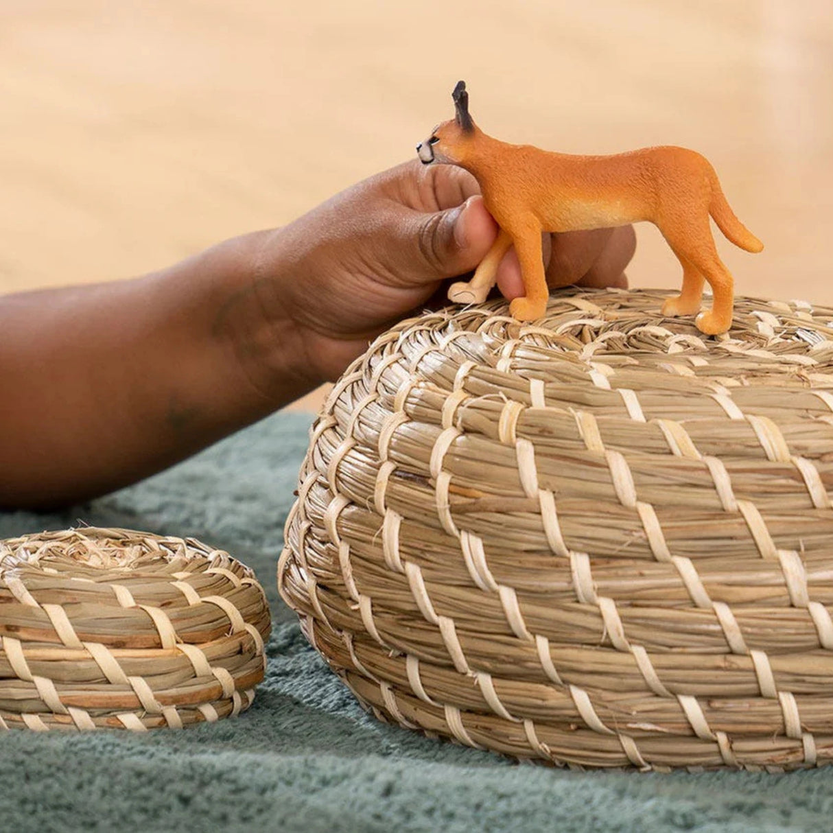 A young child playing indoors with the Schleich Caracal Female wild animal toy
