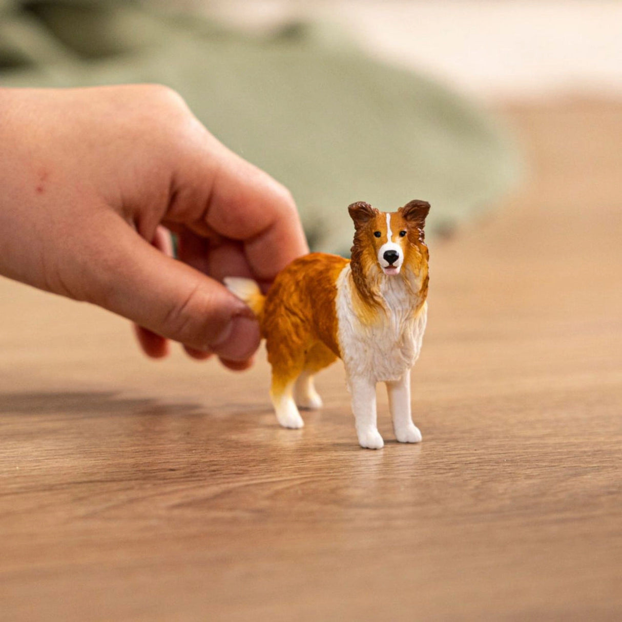 Child playing with a Schleich Collie farm animal toy in a playroom