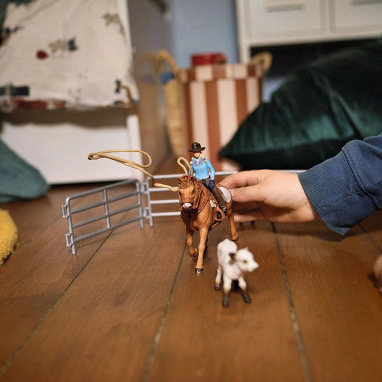 Child playing with Schleich Cowgirl Team Roping Fun farm animal toys in a colorful playroom