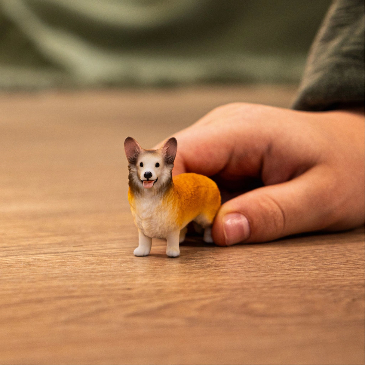 A child playing with the Schleich Welsh Corgi farm animal toy inside a playroom