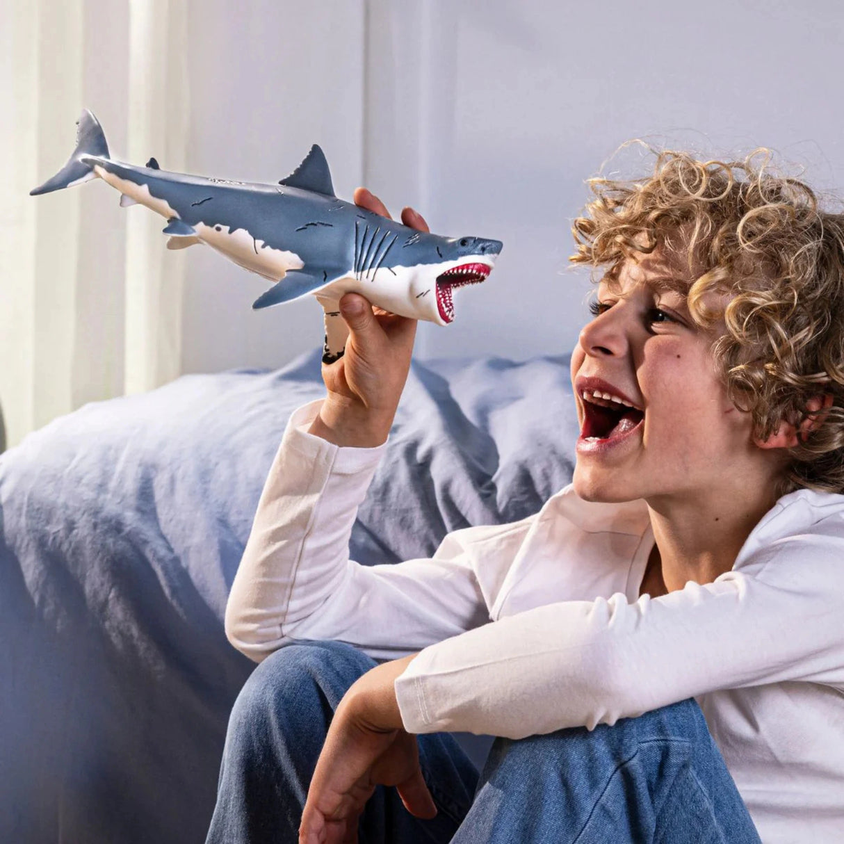 Schleich Grey Megalodon Dinosaur Toy being played with indoors by a young child