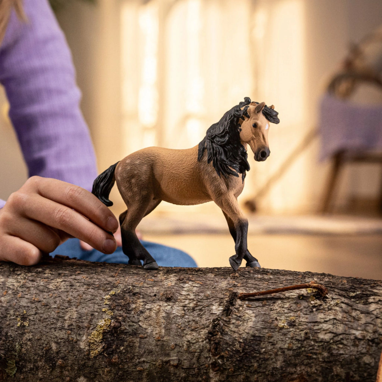 A young child imagining a horse adventure with the Schleich horse toy inside a playroom