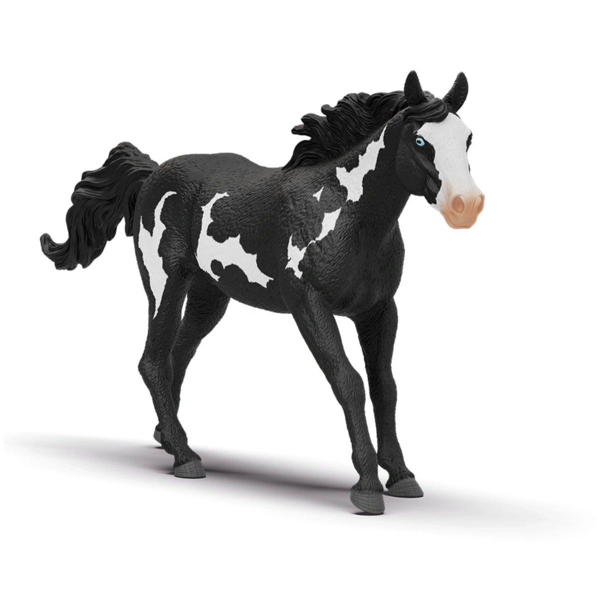 A close-up view of Schleich Paint Horse Gelding toy horse on a white background