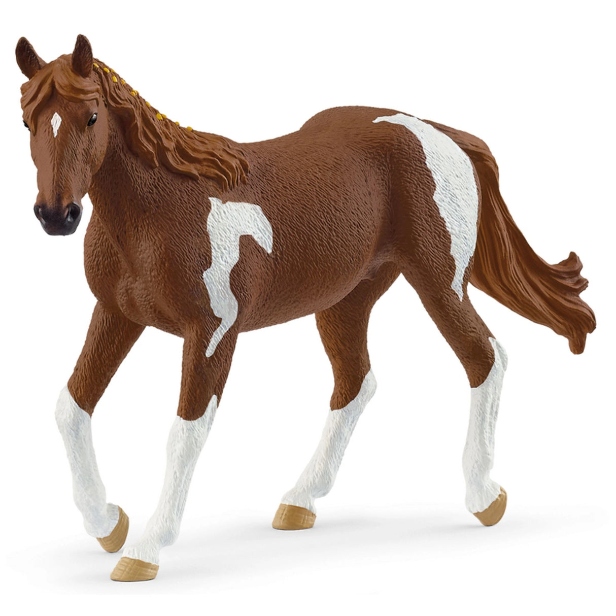 A close-up view of Schleich horse toy Paint Horse Mare on a white background