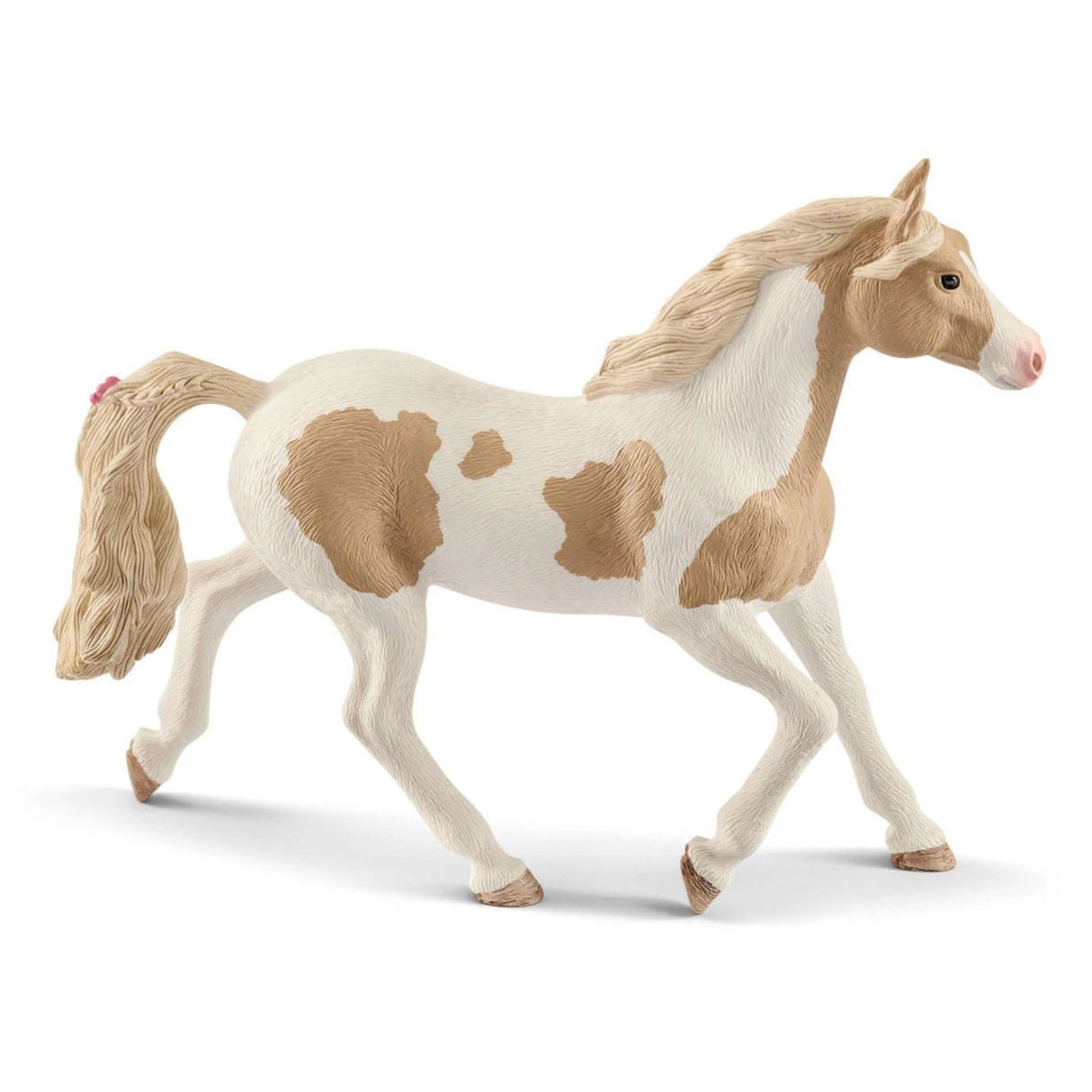 A close-up view of Schleich Horse Club Paint Horse Mare figurine on a white background