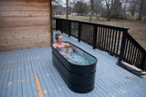 Woman sitting in ice bath on a deck