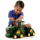 A child playing with the Bruder John Deere Toy 9620RX Crawler Track Tractor