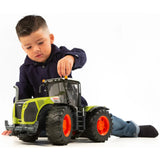 Child playing indoors with Bruder Claas Xerion tractor toy