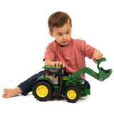 A Bruder Front Loader John Deere Toy being played with by a child indoors