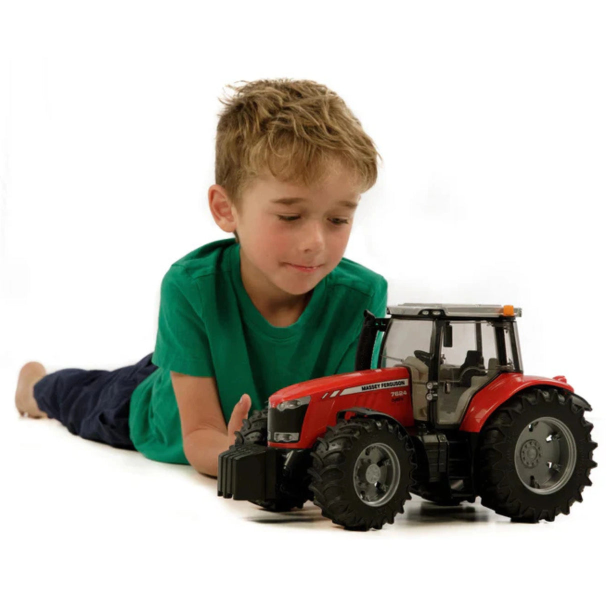 A Bruder Massey Ferguson tractor toy being played by a kid