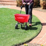 EarthWay residential fertilizer spreader being used outdoors on a lush lawn in Kamloops, British Columbia