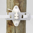 A close-up view of Dare Equine Fencing Tape Slicing Buckle 40mm Pack of 5 installed on a wooden post, securing a poly tape