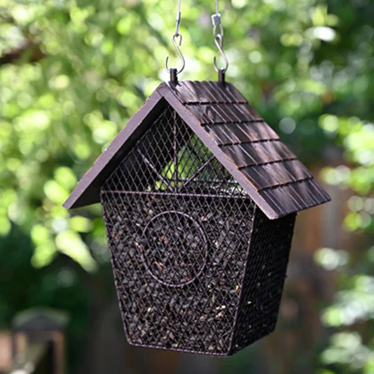 Pinebush Shingled House Style Mesh Bird Feeder installed on a tree branch in a backyard outdoors in Kamloops, British Columbia
