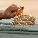 A young child playing with Schleich Caracal Baby Wild Animal Toy indoors