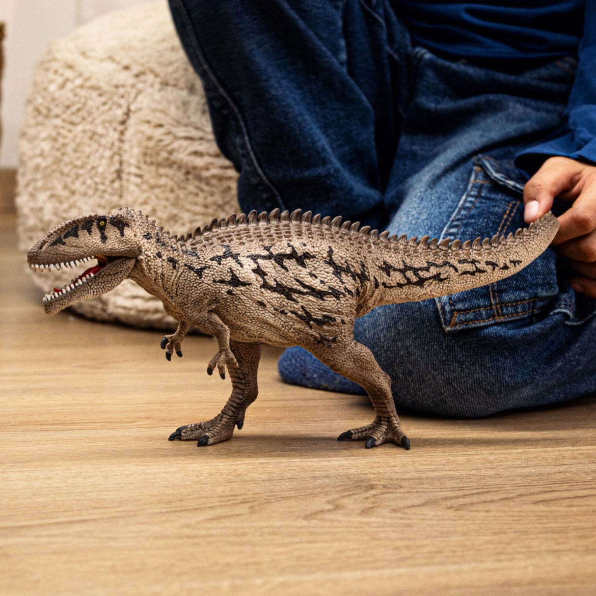 Child playing with Schleich Carcharodontosaurus dinosaur toy