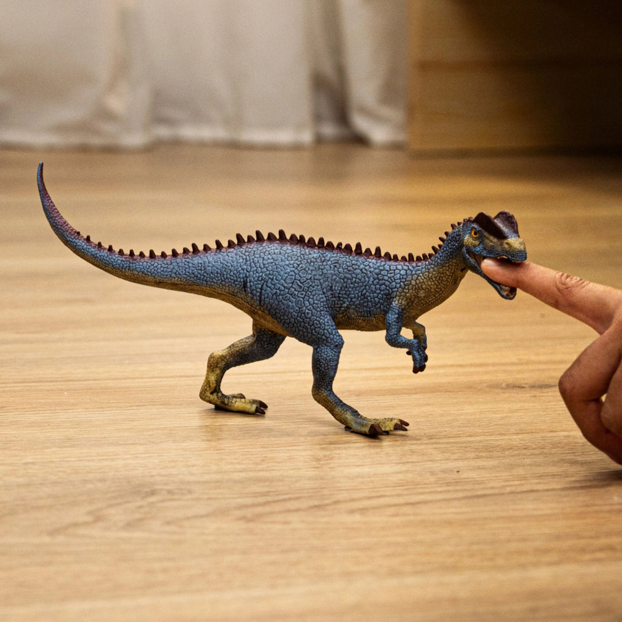 Young child enjoying imaginative play with Schleich Dinosaur Toy Dilophosaurus in playroom