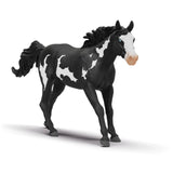 A close-up view of Schleich Paint Horse Gelding toy horse on a white background