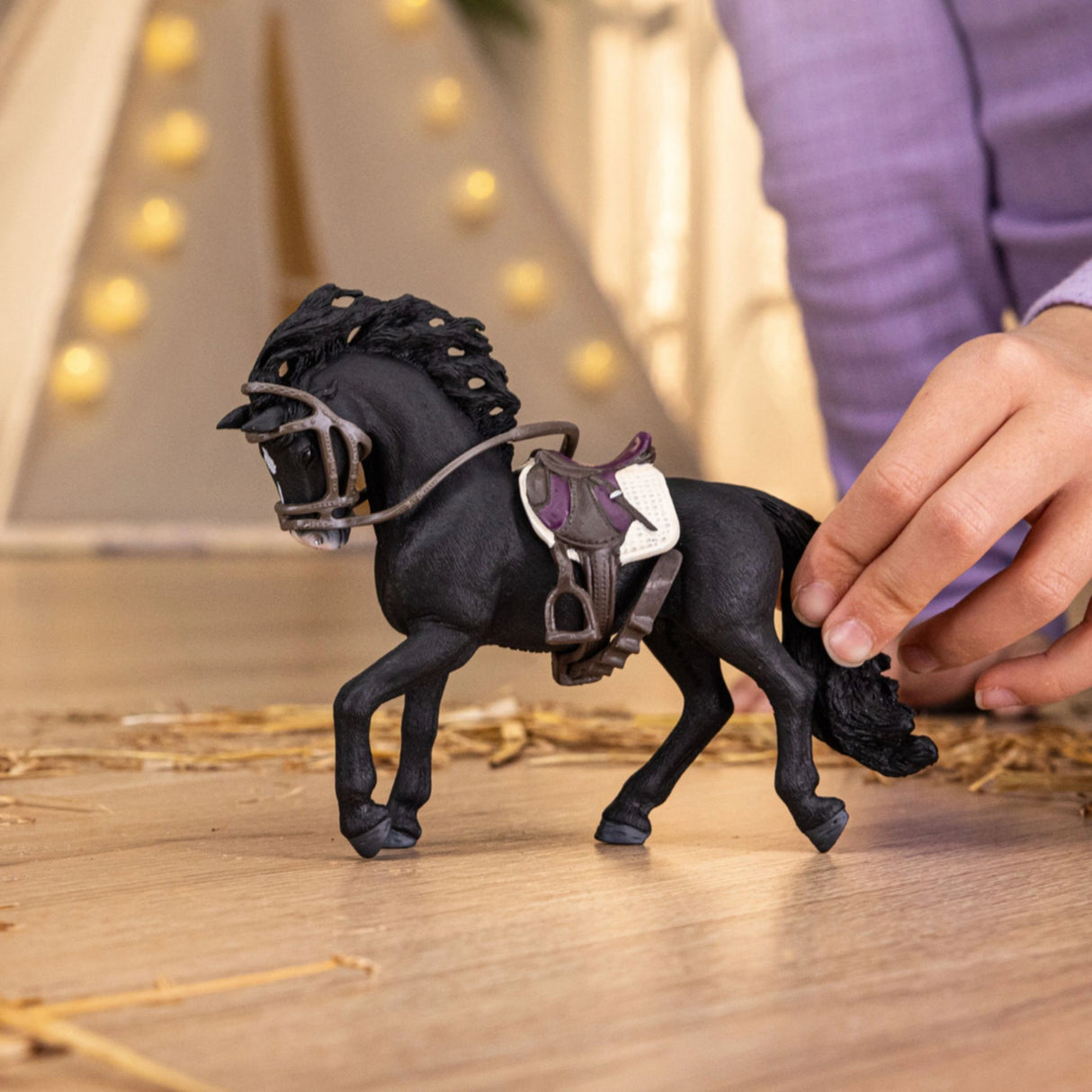 Young child engaging with Schleich Horse Club Pura Raza Española Stallion toy during imaginative play indoors