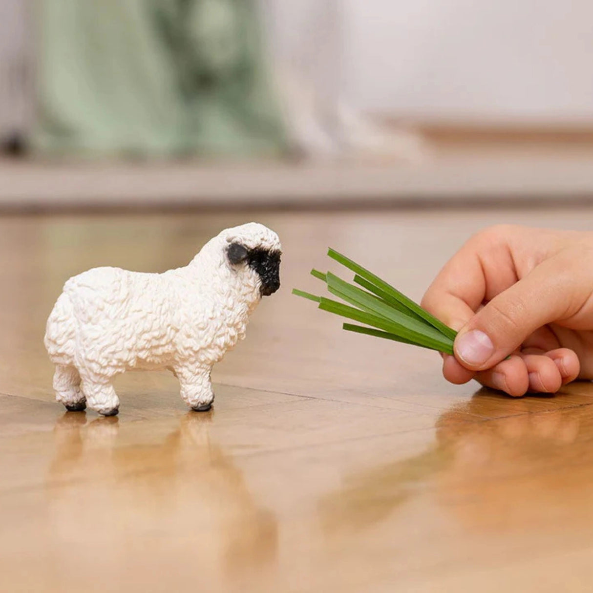 Schleich Valais Blacknose Sheep Farm Animal Toy being played by a child indoors