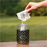 A close-up view of Terro Fly Trap Replacement Bait 6gm powder being poured into a fly trap container, in the outdoors in Kamloops, British Columbia